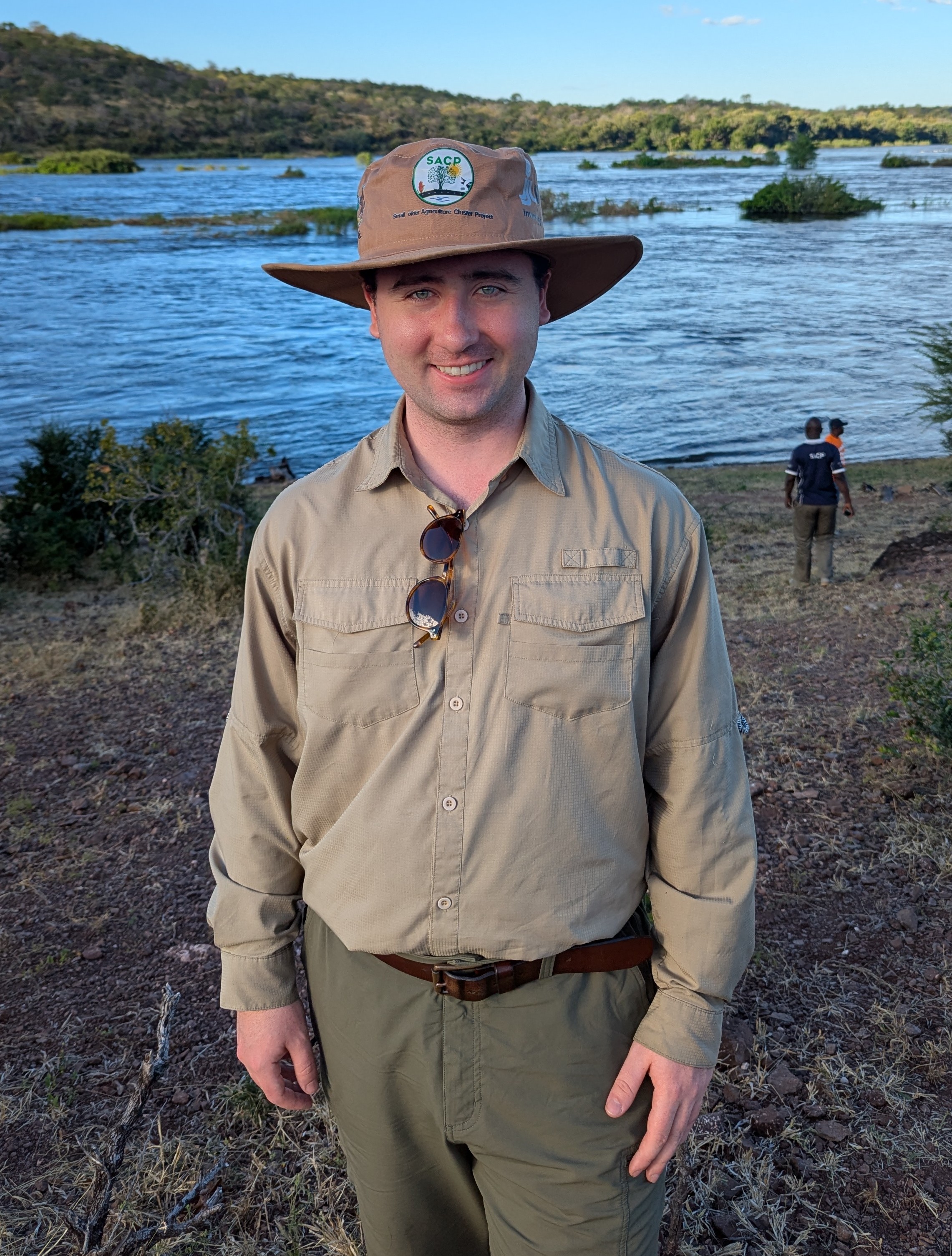 Storm Sivak standing beside the Zambezi River in Zimbabwe during field research.